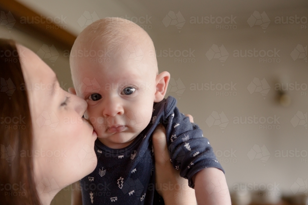 Mother kissing baby on the cheek - Australian Stock Image