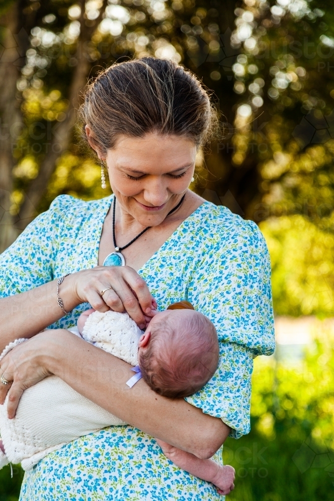 Mother looking at her newborn daughter smiling outside - Australian Stock Image