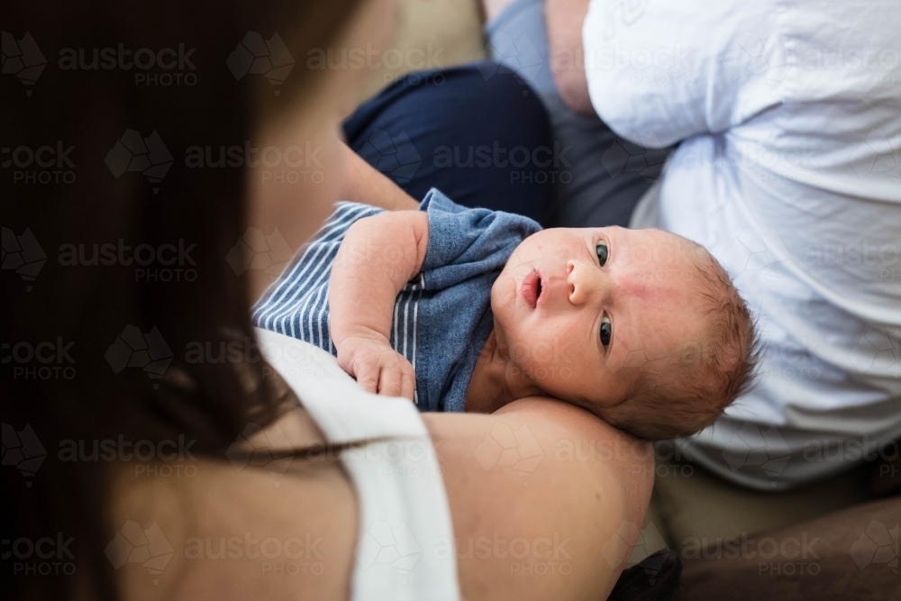 Mother nursing newborn baby boy in her arms - Australian Stock Image