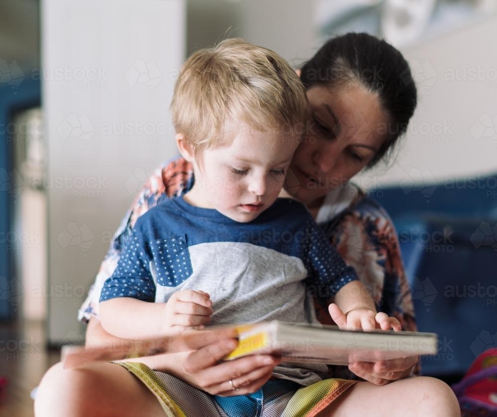 Mother reading to her child on the floor - Australian Stock Image