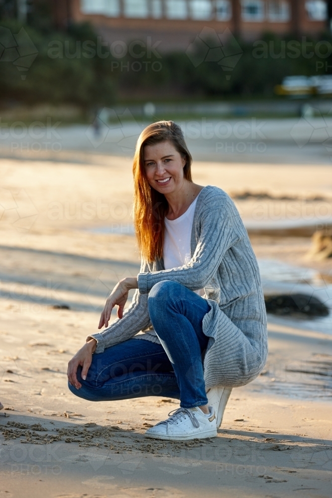 Mother smiling at beach on sunset - Australian Stock Image