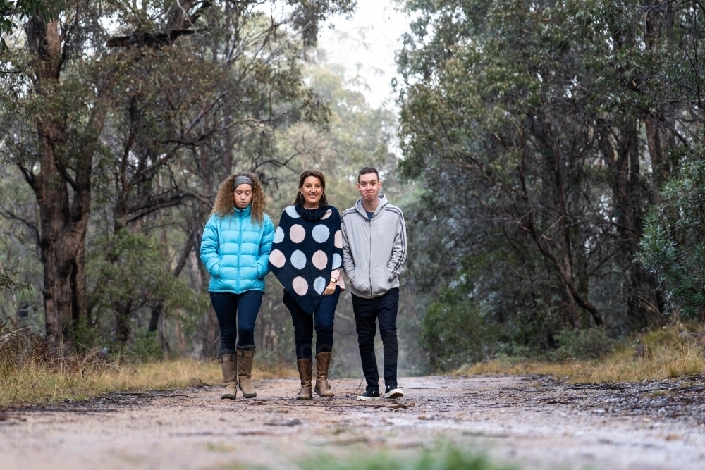 Mother, son and daughter walking on dirt track - Australian Stock Image