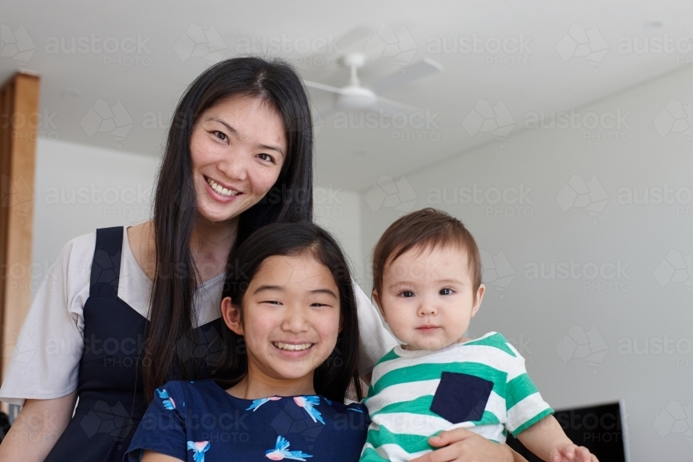 Mother with daughter and baby boy at home - Australian Stock Image