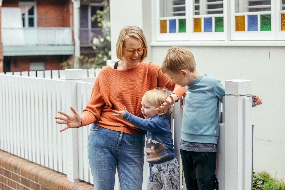 Mother with her two children out the front of their house - Australian Stock Image