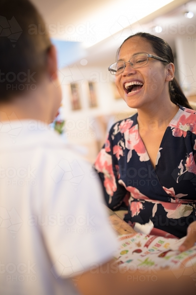 Mother with little boy opening Christmas presents at home - Australian Stock Image