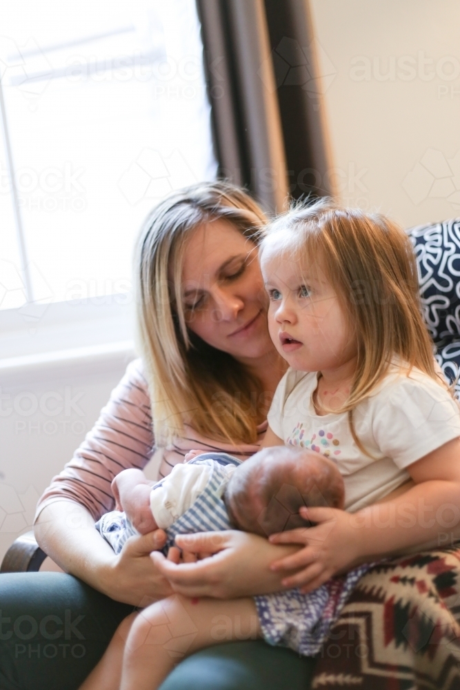 Mother with two children sitting on her lap - Australian Stock Image