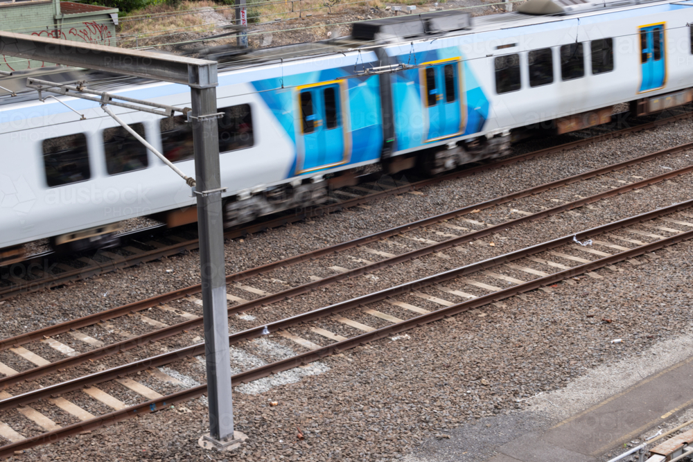 motion blur of commuter train going past railway tracks - Australian Stock Image