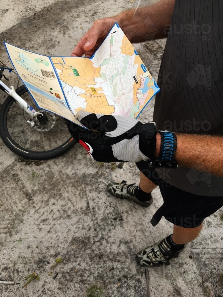 Mountain Biker looking at Map of Munda Biddi Cycling trail - Australian Stock Image