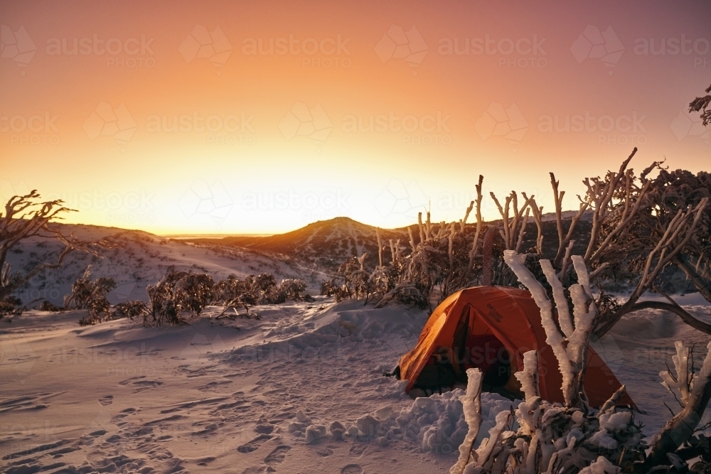Mountain vista snow camping overlooking a sunrise at dawn with fresh snow and ice - Australian Stock Image