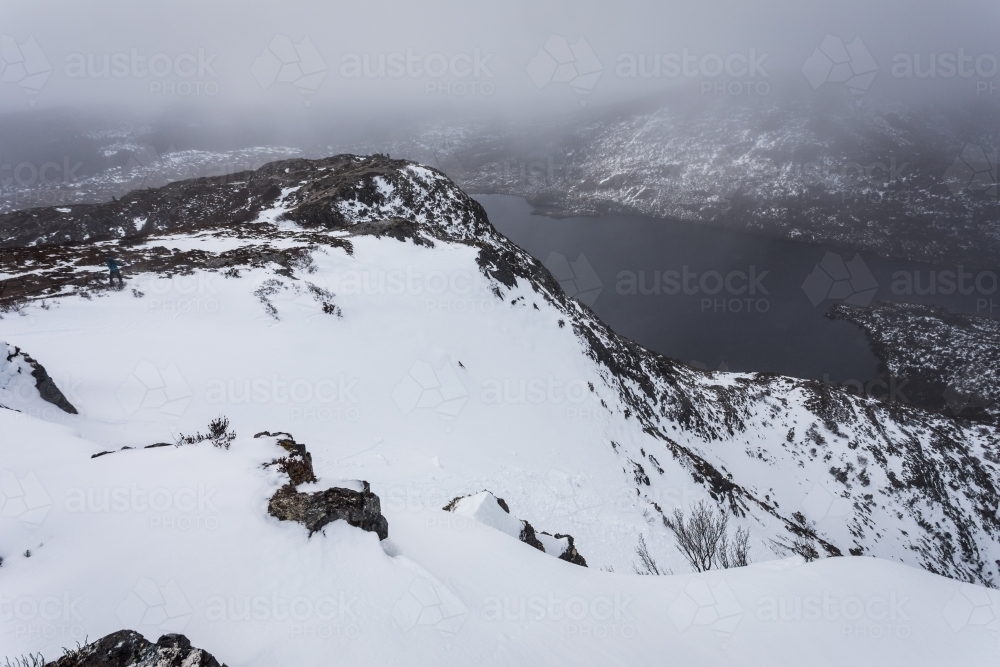 Mountains covered in snow surrounding lake - Australian Stock Image