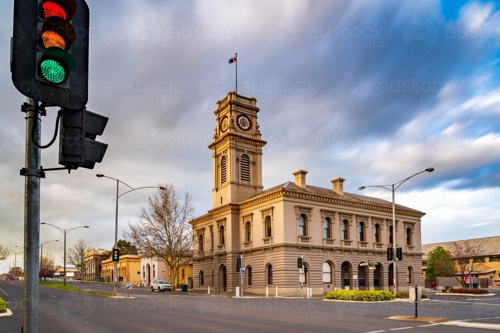Moving clouds over a town intersection with traffic lights and an historic post office - Australian Stock Image