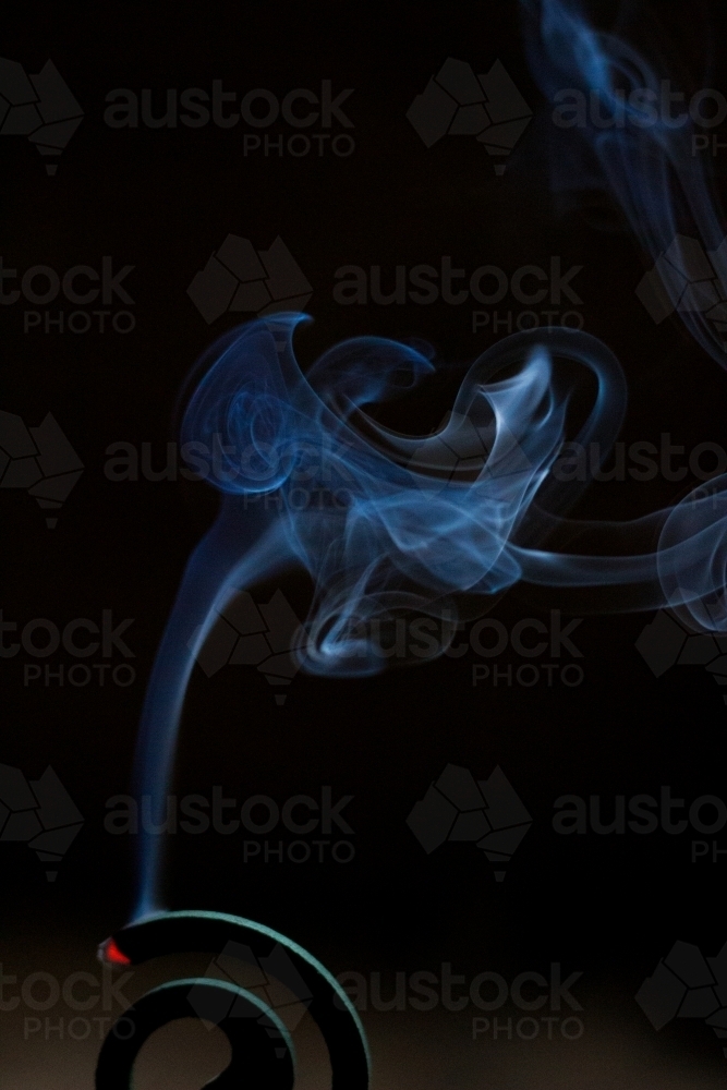 Mozzie coil burning smoke in the dark - Australian Stock Image