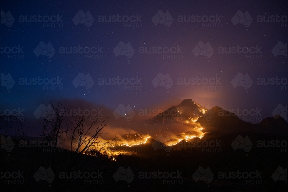 Mt Barney glowing with a line of fire over it - Australian Stock Image