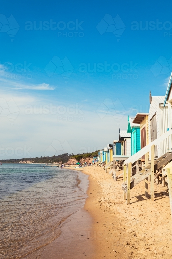 Mt Martha beach boxes with people in the distance - Australian Stock Image
