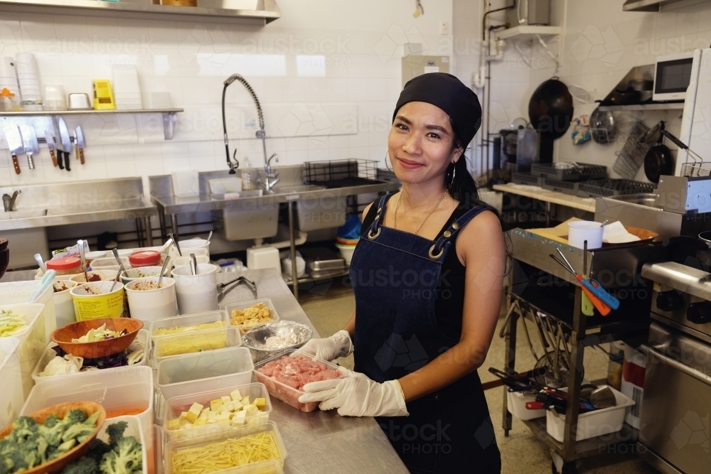 Multicultural Asian chef cooking in Thai small business restaurant - Australian Stock Image