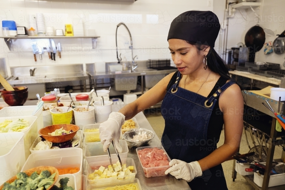 Multicultural Asian chef cooking in Thai small business restaurant - Australian Stock Image