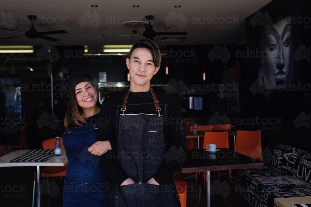 Multicultural Asian small business owners greeting in front of Thai restaurant : Austockphoto Multicultural Asian small business owners greeting in front of Thai restaurant - Australian Stock Image