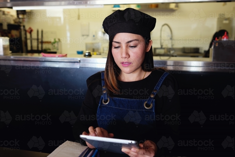 Multicultural Asian waitress taking order at Thai restaurant - Australian Stock Image