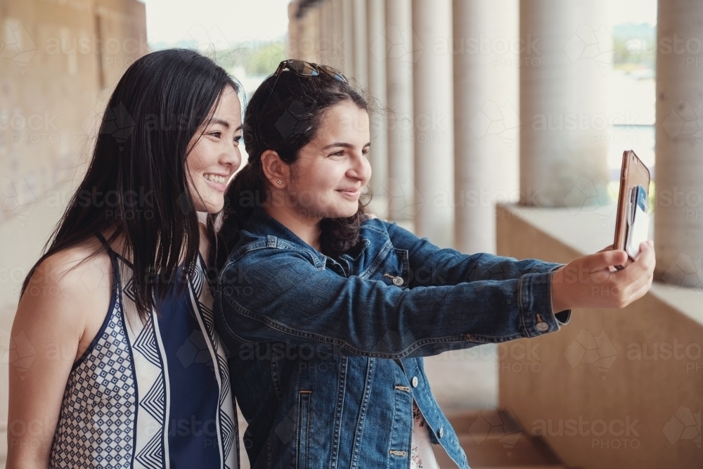 multicultural female young adult friends taking selfie - Australian Stock Image