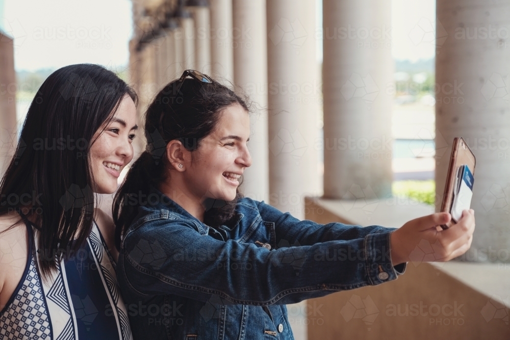 multicultural female young adult friends taking selfie - Australian Stock Image