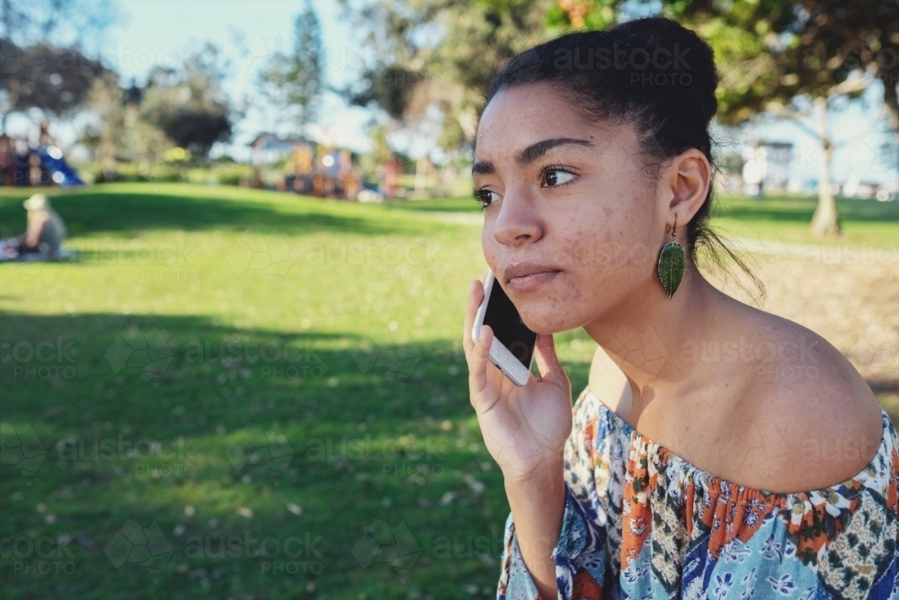 Multicultural teen girl using mobile phone - Australian Stock Image