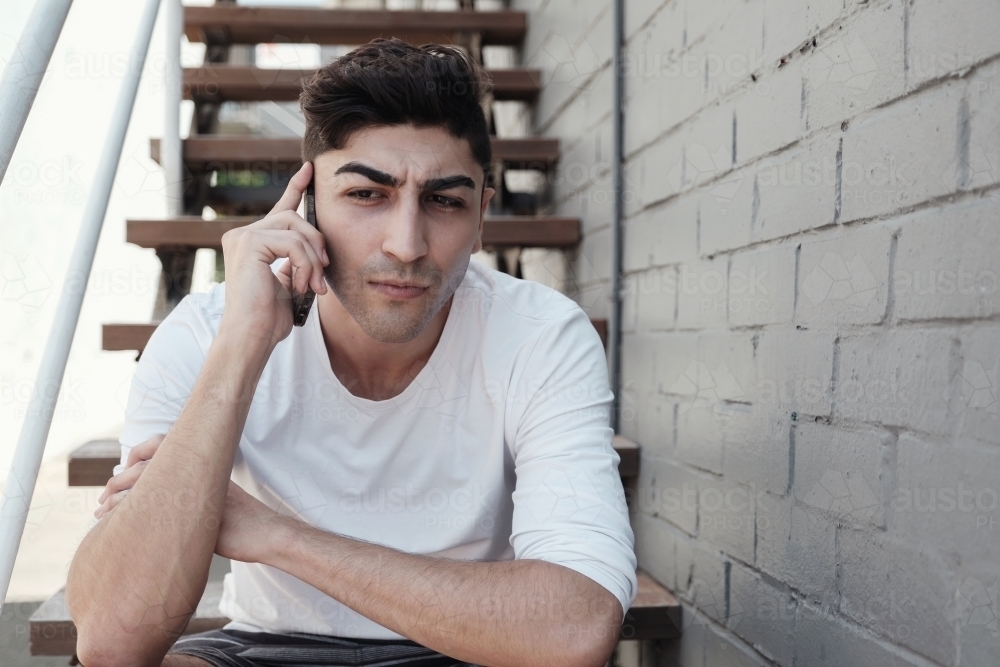 multicultural young adult man on the phone - Australian Stock Image