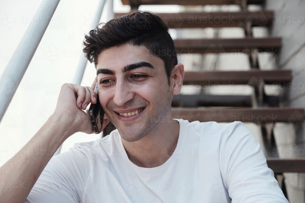 multicultural young adult man on the phone - Australian Stock Image