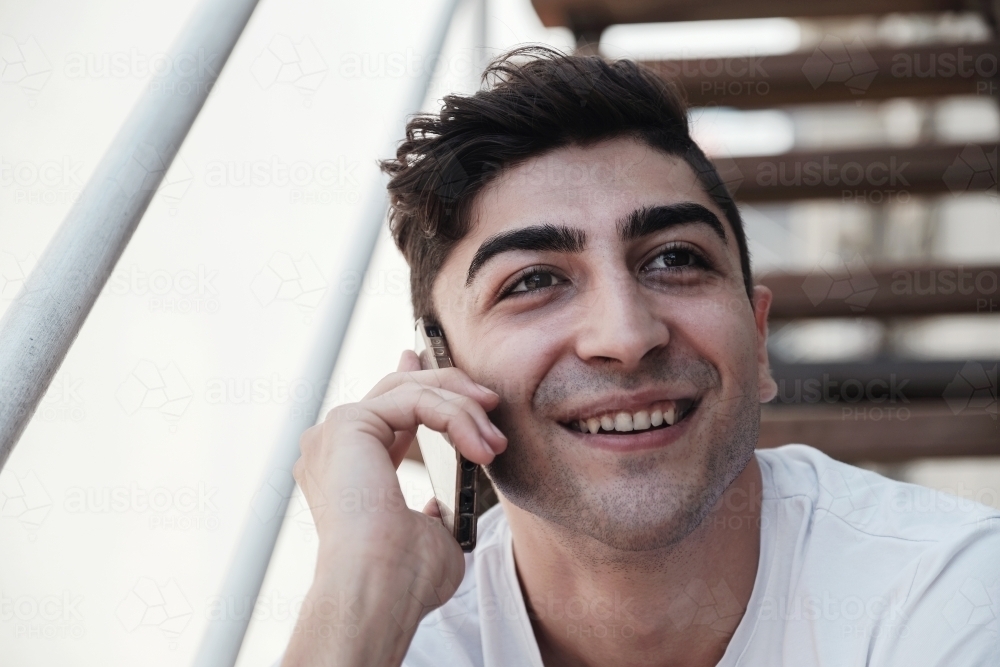 multicultural young adult man on the phone - Australian Stock Image