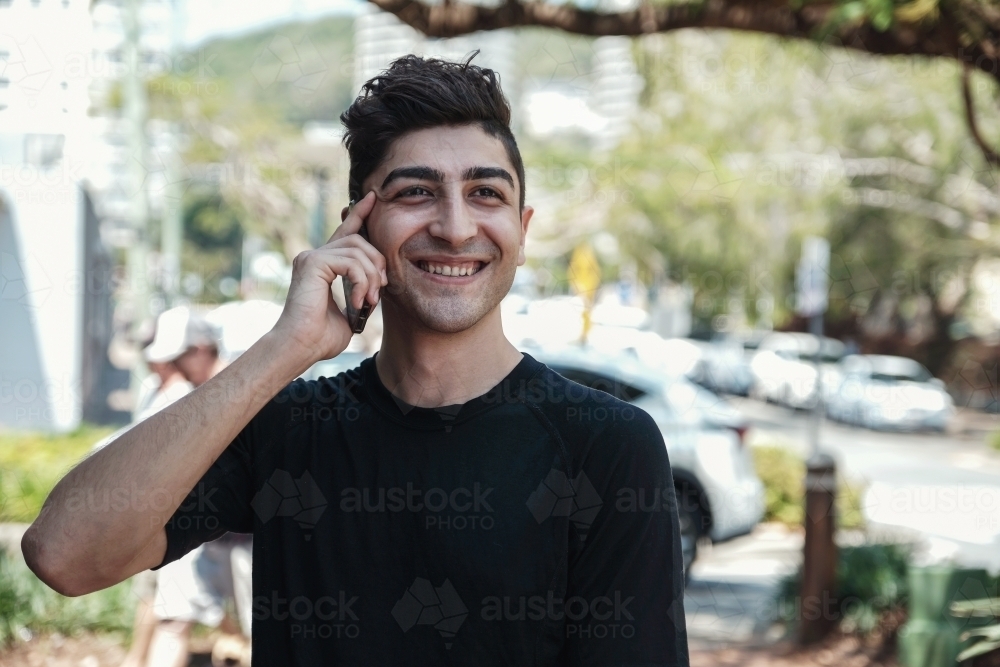 multicultural young adult man on the phone - Australian Stock Image