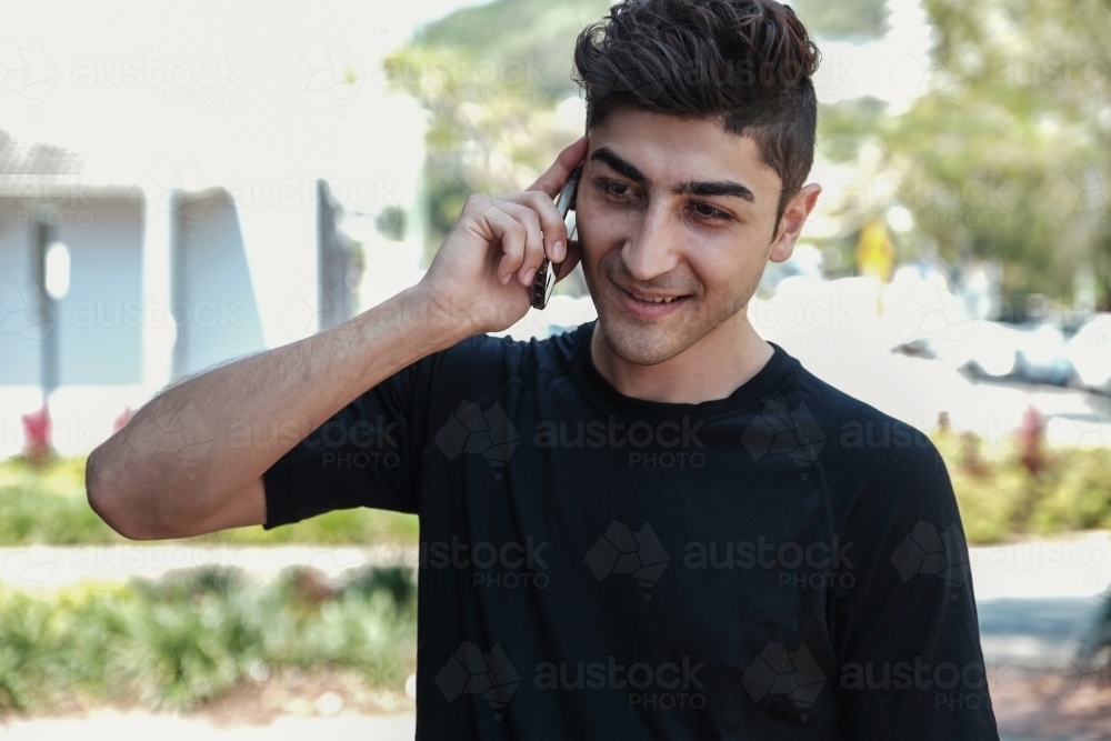 multicultural young adult man on the phone - Australian Stock Image