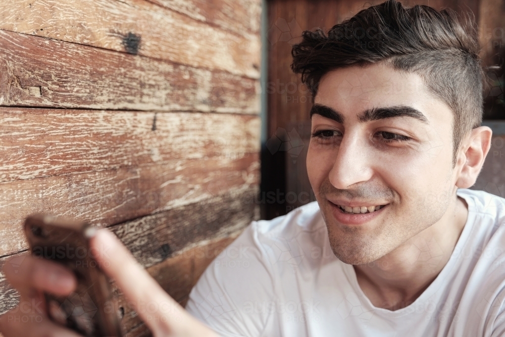 multicultural young adult man using smartphone - Australian Stock Image