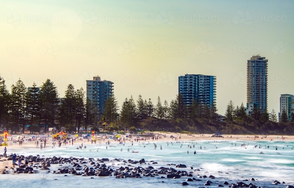 Multiple people at the beach on a hot and hazy summer afternoon. - Australian Stock Image