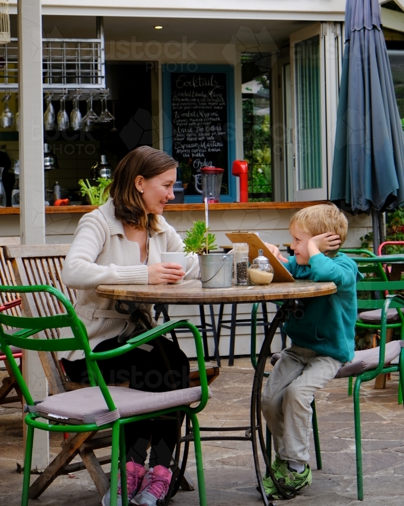 Mum and son looking at a menu in a cafe restaurant - Australian Stock Image