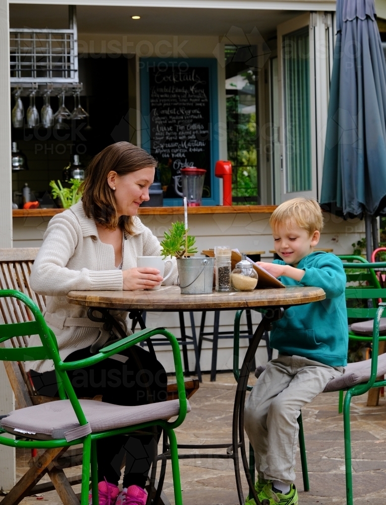 Mum and son looking at a menu in a cafe restaurant - Australian Stock Image