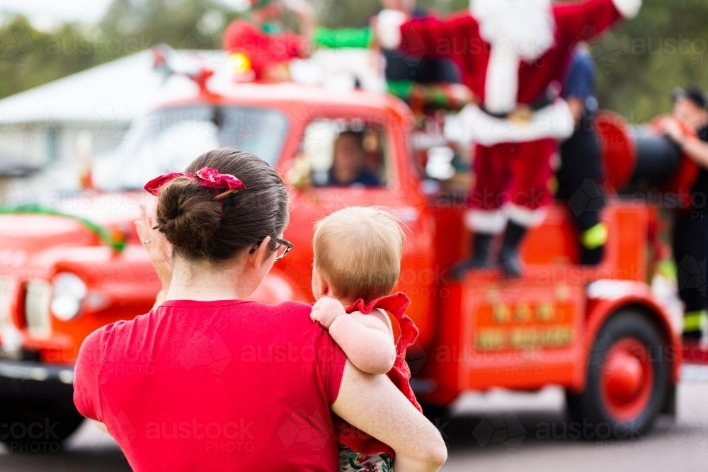 Image of Mum holding baby to see the lolly run fire truck with Santa at ...