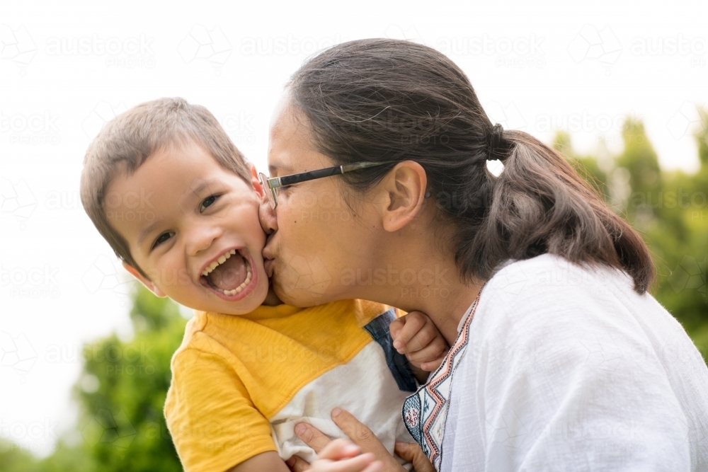 Mum playing and laughing with her two year old son outside - Australian Stock Image