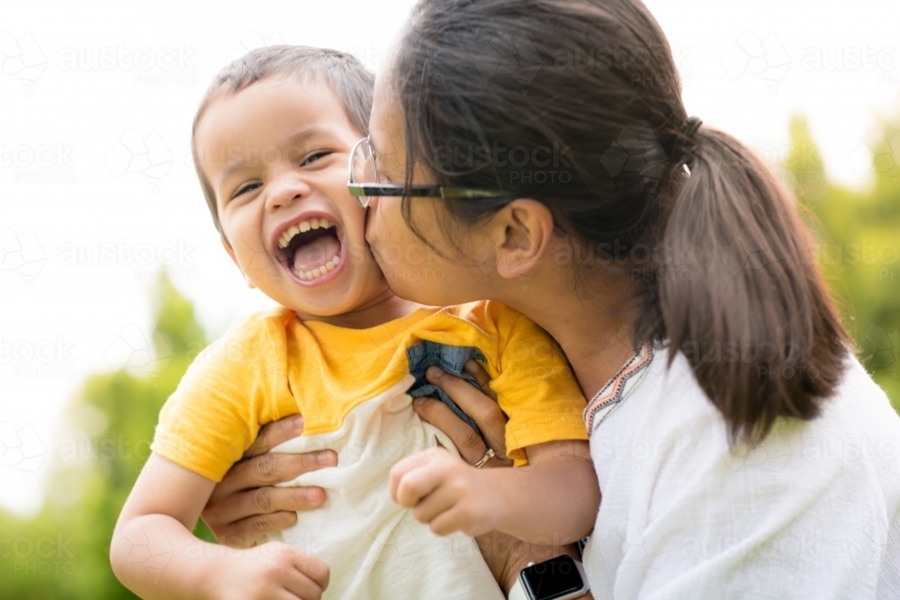 Mum playing and laughing with her two year old son outside - Australian Stock Image