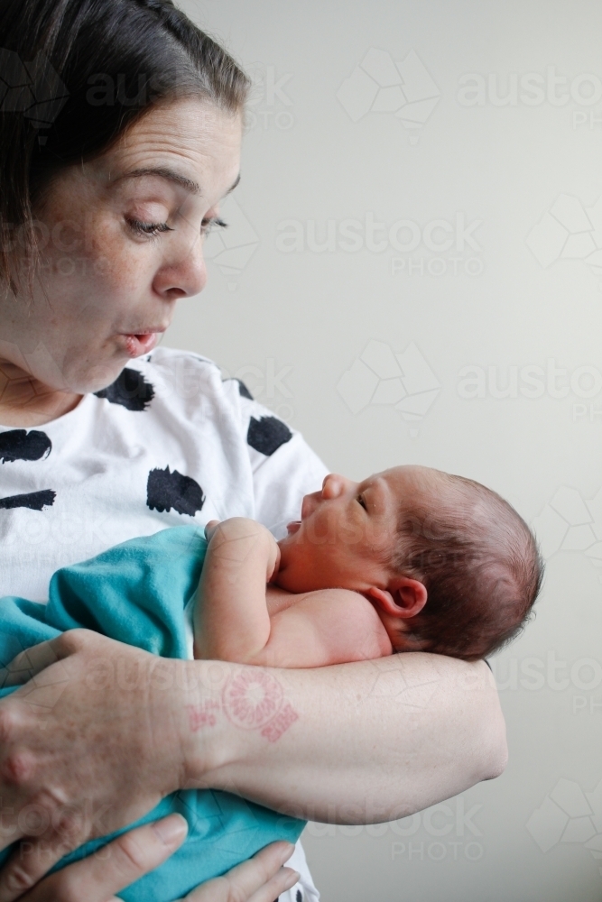 Mum pulling a surprised face at her newborn son - Australian Stock Image