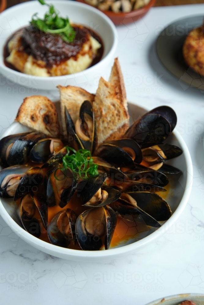 Image of Mussels in chili curry butter with spring onion and toast