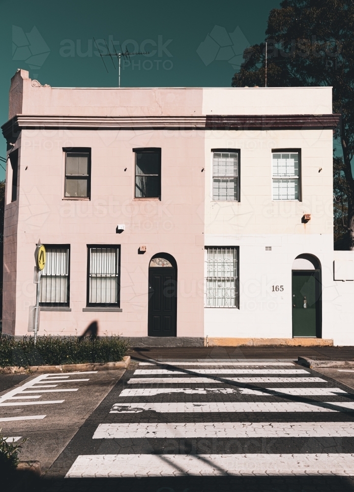 muted pink heritage houses on the street at a pedestrian crossing - Australian Stock Image