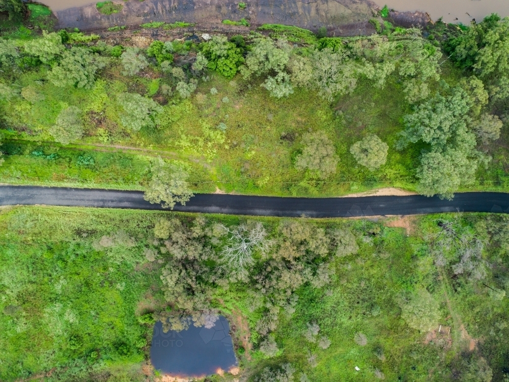 Narrow road going through green paddocks - Australian Stock Image