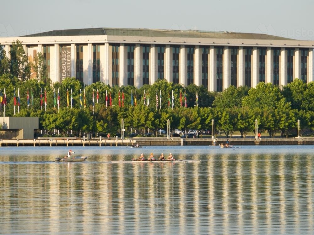 National Library, Canberra, reflected in Lake Burley Griffin with rowers - Australian Stock Image