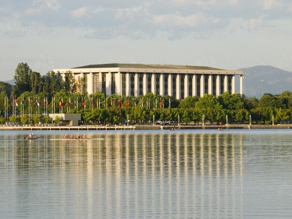 National Library of Australia reflected in Lake Burley Griffin with rowers - Australian Stock Image