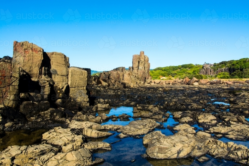 Natural rock formations with blue sky reflecting off the puddles - Australian Stock Image