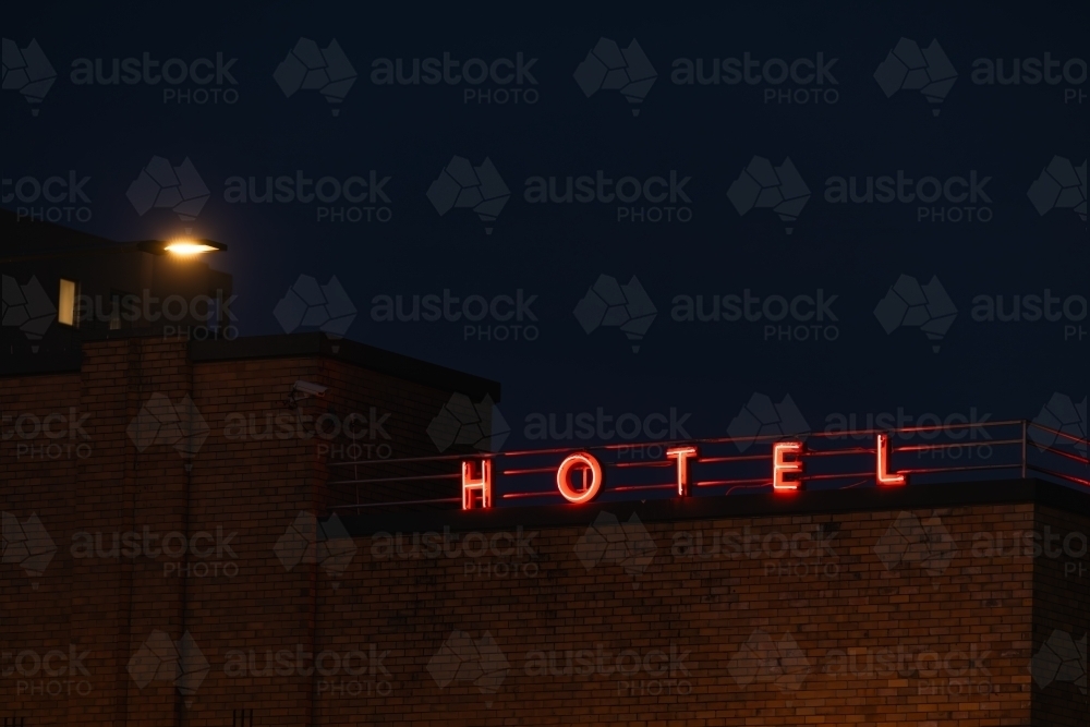 Image of Neon Hotel sign illuminated on top of building at night time ...