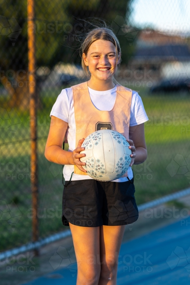 netball player holding ball and smiling - Australian Stock Image