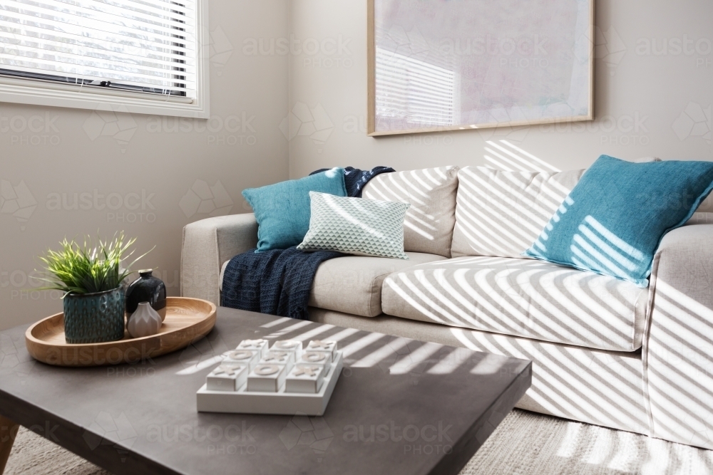 Neutral living room with textured fabrics and teal accents - Australian Stock Image