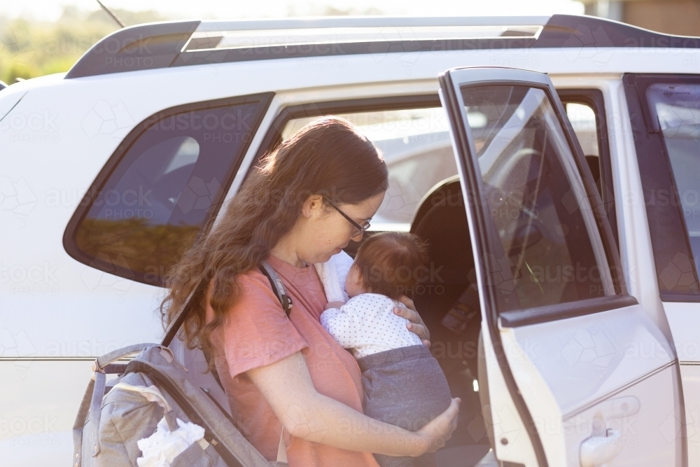 New mum putting baby in car to go out and about with newborn - Australian Stock Image