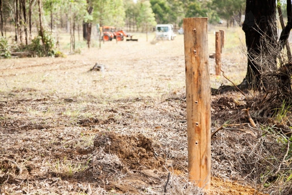 New post of farm boundary fence with holes drilled through it for the wire - Australian Stock Image