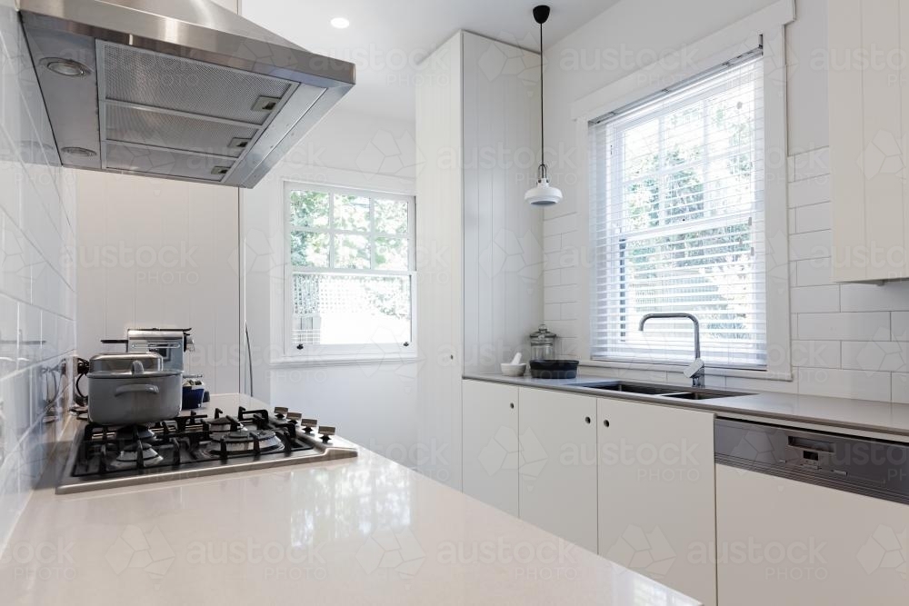 New renovated crisp white galley style kitchen in Australian apartment - Australian Stock Image